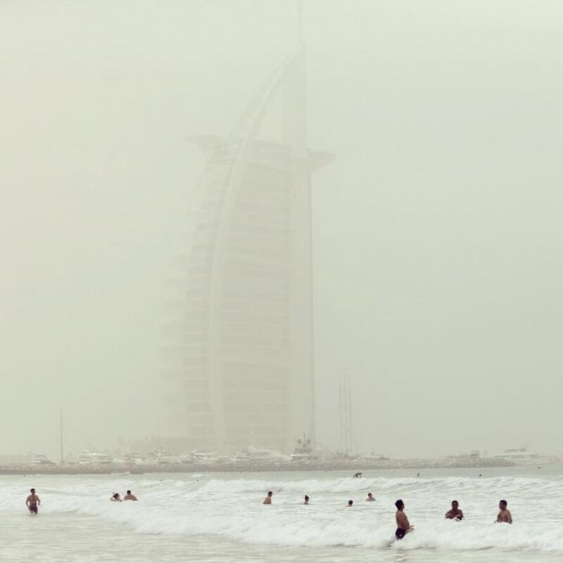 Swimmers enjoy the beach on a dusty day in Dubai, UAE . Photo by Sarah Dea (@sarahmcgregore).