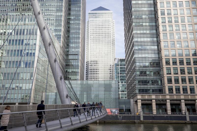 Commuters walk across a footbridge in the Canary Wharf business, financial and shopping district in London, U.K. on Monday, March 9, 2020. As the coronavirus spreads, British bankers are preparing to use trading sites miles from London’s City and Canary Wharf -- and their regulators are keeping a keen eye on that contingency planning. Photographer: Jason Alden/Bloomberg