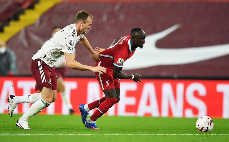 epa08704774 Sadio Mane (R) of Liverpool in action against Rob Holding of Arsenal during the English Premier League match between Liverpool and Arsenal London in Liverpool, Britain, 28 September 2020.  EPA/Paul Ellis / POOL EDITORIAL USE ONLY. No use with unauthorized audio, video, data, fixture lists, club/league logos or 'live' services. Online in-match use limited to 120 images, no video emulation. No use in betting, games or single club/league/player publications.