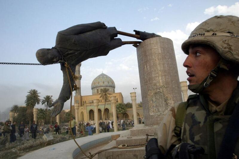 U.S. Marine Corp Assaultman Kirk Dalrymple watches as a statue of Iraq’s President Saddam Hussein falls in central Baghdad on April 9, 2003. Goran Tomasevic / Reuters