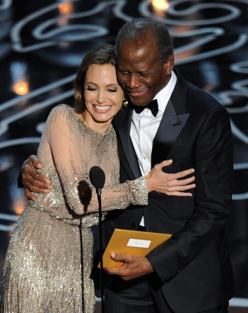 Actors Angelina Jolie and Sidney Poitier walk onstage. Kevin Winter / Getty Images / AFP