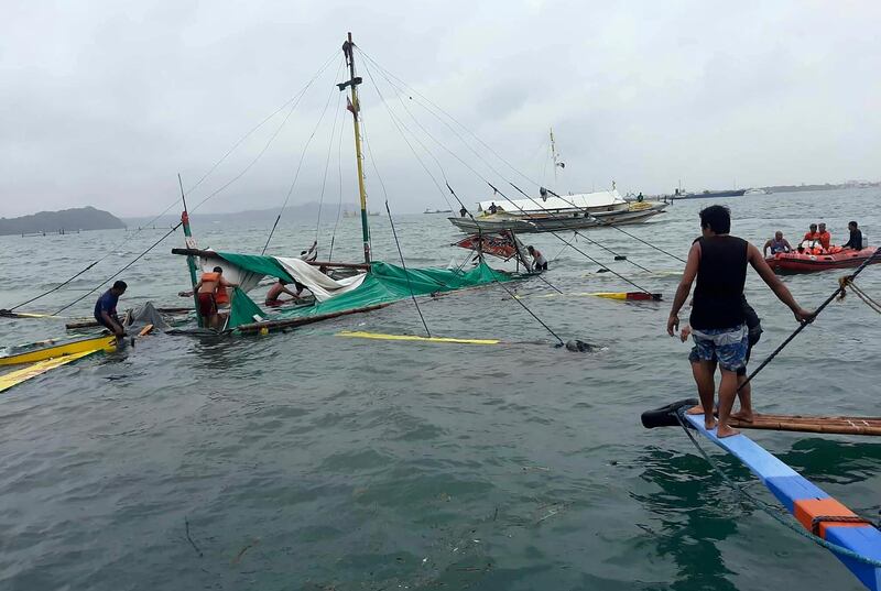 Rescuers check the remains of a ferry boat after it capsized. Philippine Red Cross via AP
