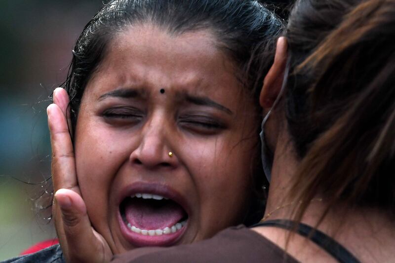 Family members and relatives of passengers on board the Twin Otter aircraft operated by Tara Air, weep outside the airport in Pokhara on May 29, 2022.  - A passenger plane with 22 people on board went missing in Nepal on May 29, the operating airline and officials said, as poor weather hampered a search operation.  (Photo by PRAKASH MATHEMA  /  AFP)