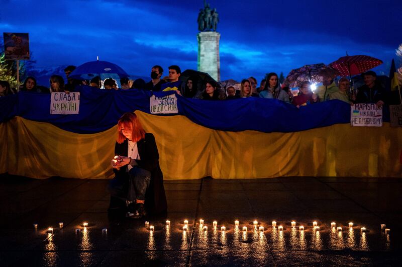 A woman lights candles during a demonstration to support Ukraine in downtown Sofia. AFP