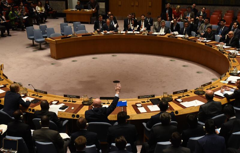 The UN Security Council votes to  extend investigations into who is responsible for chemical weapons attacks in Syria at the United Nations on October 24, 2017. 
Russian Ambassador to the UN Vassily Nebenzia(raising his hand) voted no to the resolution. / AFP PHOTO / TIMOTHY A. CLARY