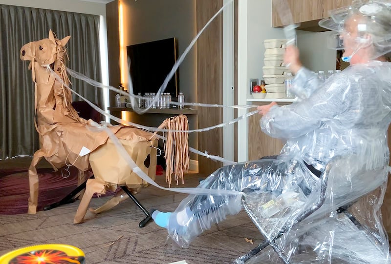 David Marriott poses with his paper horse in his hotel room in Brisbane, Australia, April 6, 2021. While in quarantine inside his Brisbane hotel room, art director Russell Brown was bored and started making a cowboy outfit from the paper bags his meals were being delivered in. His project expanded to include a horse and a clingfilm villain that he has daily adventures with, in images that have gained a huge online following. (David Marriott via AP)