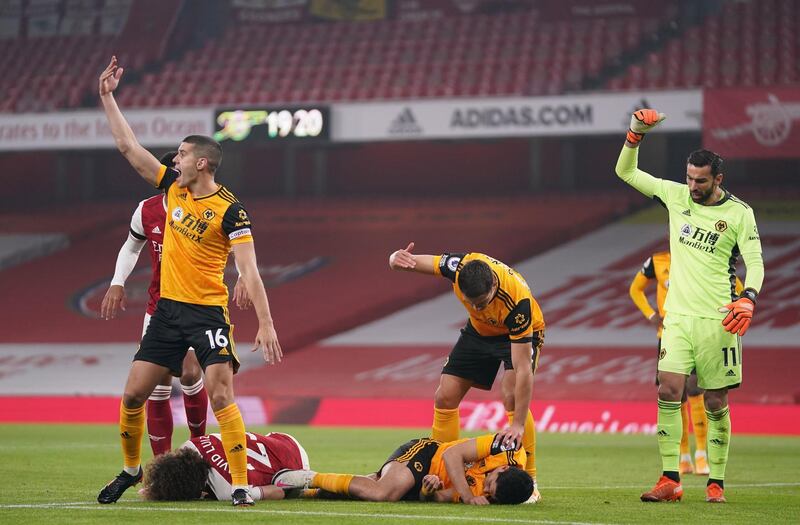 epa08852107 Players gesture for help after David Luiz of Arsenal (L) and Raul Jimenez of Wolverhampton (R) head clashed during the English Premier League soccer match between Arsenal FC and Wolverhampton Wanderers in London, Britain, 29 November 2020.  EPA/John Walton / POOL EDITORIAL USE ONLY. No use with unauthorized audio, video, data, fixture lists, club/league logos or 'live' services. Online in-match use limited to 120 images, no video emulation. No use in betting, games or single club/league/player publications.