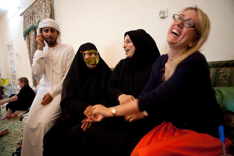 Al Rams, Ras Al Khaimah, United Arab Emirates - July 17 2013 - (L-R) Suqrat Bin Bisher, Fatima Bisher, Aisha Bisher and Dr. Natasha Ridge, Executive Director of the Al Qasimi Founation share a moment after Iftar.  Expats attended their first Iftar at Fatima Bisher's home in Al Rams, Ras Al Khaimah. The event was hosted by the Al Qasimi Foundation, which is based in RAK.  For story by Rym Ghazal. (Razan Alzayani / The National)  *** Local Caption ***  RA0718_expat_iftar_RAK019.jpg