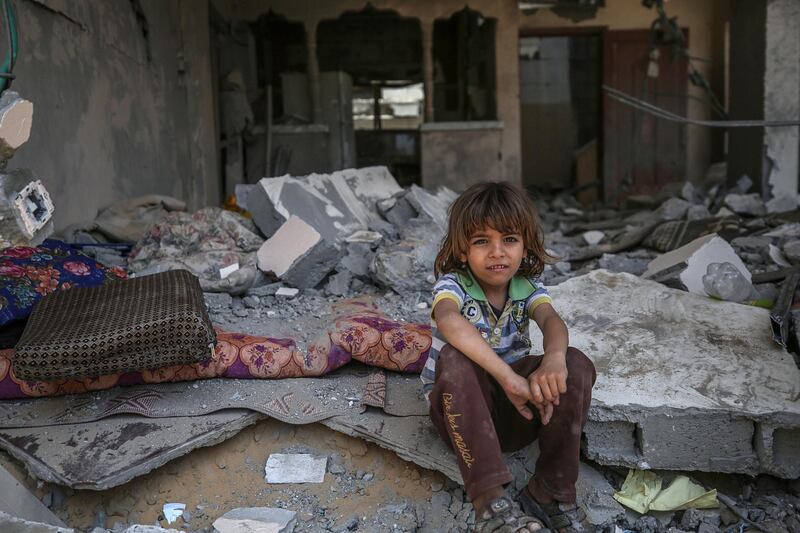 A Palestinian child sits amid the rubble of family destroyed house after a ceasefire between Israel and Gaza fighters, in Beit Hanoun, in the northern Gaza Strip. EPA