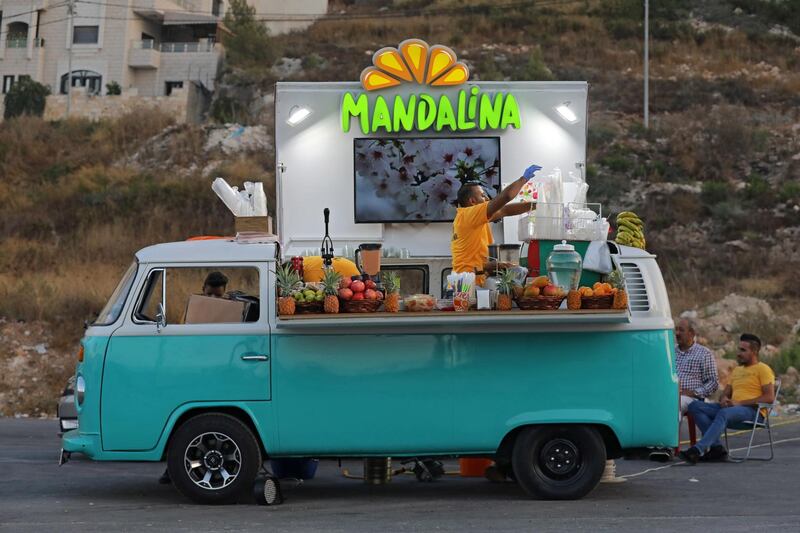 A Palestinian man uses his classic Volkswagen T2 to sell fresh juices in a street in the West Bank city of Nablus.  EPA