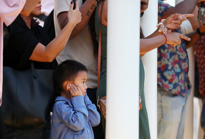 A boy covers his ears as a cannon is fired at Expo City Dubai to mark the beginning of iftar on the first day of Ramadan. Chris Whiteoak / The National