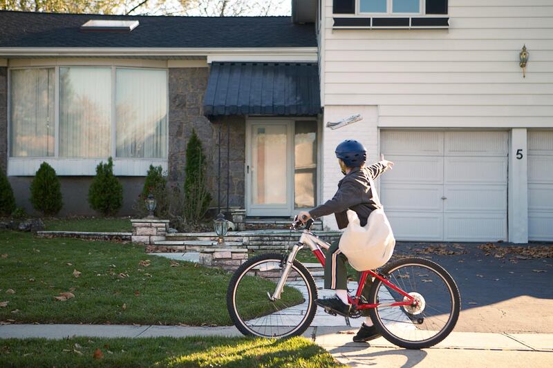 Boy delivering newspapers on his bicycle. Getty Images