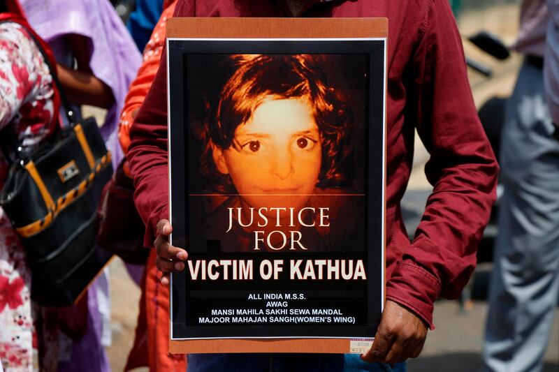 A woman protester in Srinagar holds a poster with a portrait of Asifa, an 8-year-old rape victim who was grazing her family's ponies in the forests of the Himalayan foothills in Jammu and Kashmir when she was kidnapped. Her mutilated body found in the woods a week later. Ajit Solanki / AP Photo