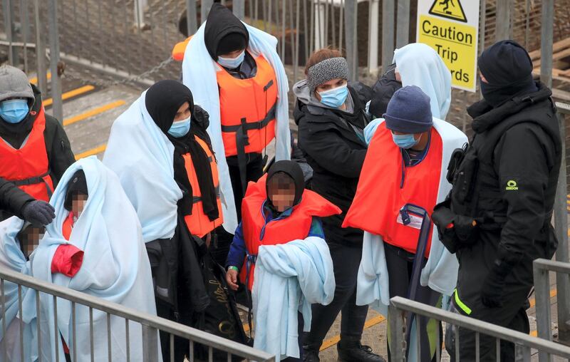 Note to eds: The picture at the bottom has been pixelated as the PA Picture Desk has been unable to gain the necessary permission to photograph a child under 16 on issues involving their welfare. The picture is also provided unpixelated for newspapers to pixelate in their own style. A group of people including young children are brought in to Dover, Kent, by Border Force officers following a small boat incident in the Channel. (Photo by Gareth Fuller/PA Images via Getty Images)