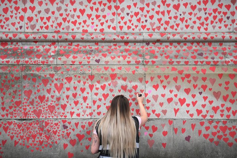 A woman adds a heart to the National Covid Memorial Wall in London. From 29 March, 2021 the UK government eased Coronavirus lockdown measures. Outdoor sport centres including swimming pools, tennis courts and golf courses are reopening. EPA
