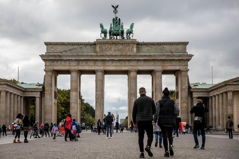 BERLIN, GERMANY - OCTOBER 12: Tourists walk at the Brandenburg Gate on October 12, 2020 in Berlin, Germany. Berlin and several cities have already breached limit of infection above 50 per 100,000 residents over a period of seven days. Cities and states have called for restrictions on social gatherings and travel to deal with the rising number of COVID-19 cases. (Photo by Maja Hitij/Getty Images)