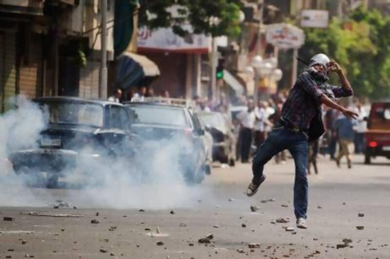 Egyptian riot police fire tear gas as supporters of ousted president Mohammed Morsi clash with residents and police in downtown Cairo.