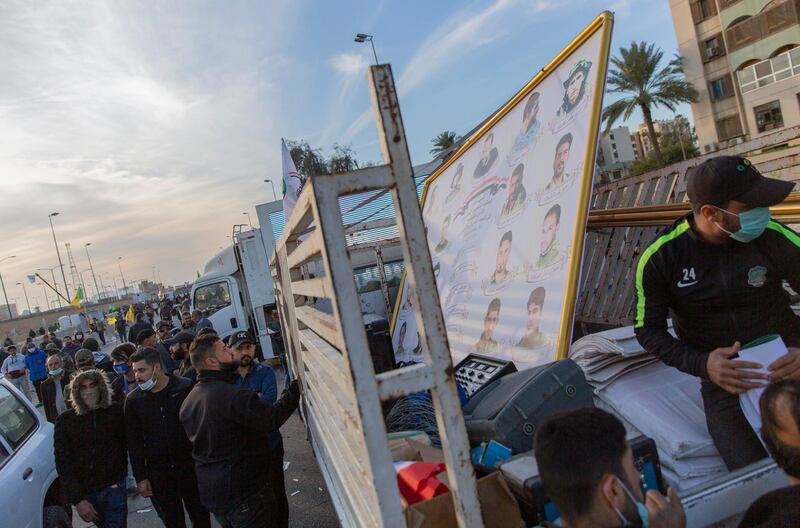 Pro-Iranian militiamen and their supporters load trucks with items from dismantled tents, in front of the US embassy, in Baghdad, Iraq. AP Photo