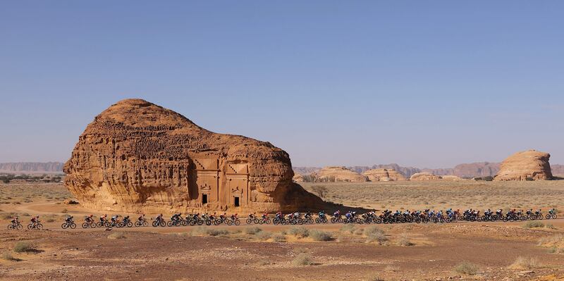 The pack rides past ancient Nabataean carved tombs