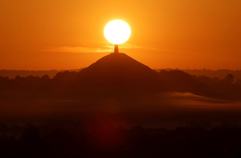 The sun rises above Glastonbury Tor in Glastonbury, Somerset, south-west England. The Tor is mentioned in Celtic mythology, including myths linked to King Arthur. Reuters