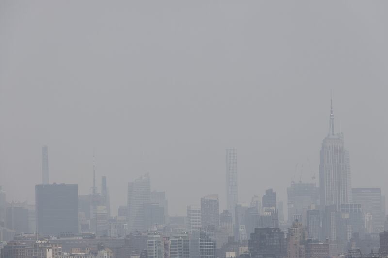 New York's Empire State Building, right, is shrouded in smoke caused by Canadian wildfires on Tuesday. Bloomberg