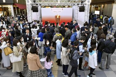 People wearing protective face masks following the outbreak of the coronavirus disease (COVID-19), queue as they try to watch the Olympic cauldron during the Tokyo 2020 Olympics Flame of Recovery tour at Sendai Station, Miyagi prefecture, Japan March 21, 2020, in this photo taken by Kyodo. Mandatory credit Kyodo/via REUTERS ATTENTION EDITORS - THIS IMAGE WAS PROVIDED BY A THIRD PARTY. MANDATORY CREDIT. JAPAN OUT.