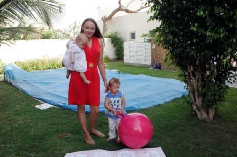 Dubai, 21st April 2011.  Dania Jackson mother of two cute baby's, Ellie (5 1/2 months) and Mia (2 years old) with the blue plastic canvass covered pool to protect her daughters from going and playing on it.  (Jeffrey E Biteng / The National)