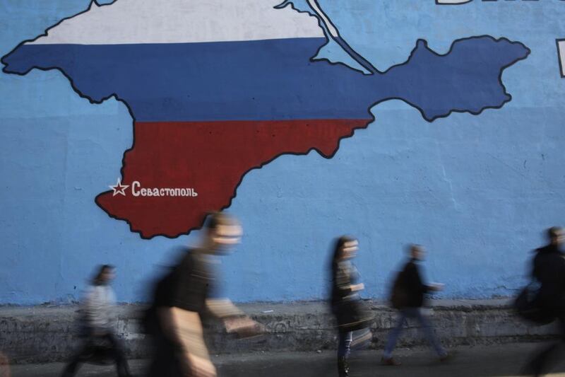 People pass a mural showing a map of Crimea in the Russian national colours on a street in Moscow.  Arthur Bainozarov / Reuters 