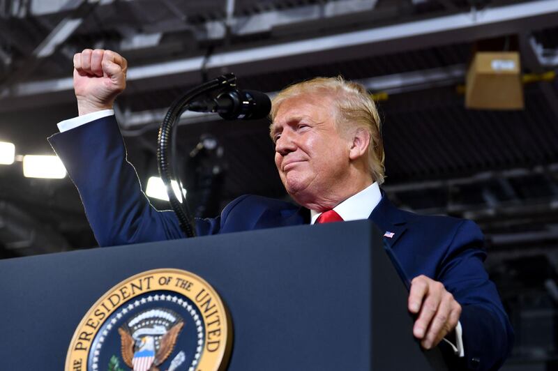 (FILES) In this file photo taken on July 17, 2019 US President Donald Trump pumps his fists as he speaks for a "Make America Great Again" rally at Minges Coliseum in Greenville, North Carolina. US President Donald Trump on July 18, 2019 sought to distance himself from the incendiary chant of "Send her back" aimed at a Somali-born Democratic lawmaker during an election rally the night before. "I was not happy with it -- I disagree with it," Trump told reporters when asked about the cry, launched by the crowd in response to an angry tirade by Trump against congresswoman Ilhan Omar. Asked why he did nothing to stop the taunt, instead pausing as the crowd chanted it over and over, Trump responded: "I think I did -- I started speaking very quickly."
 / AFP / Nicholas Kamm
