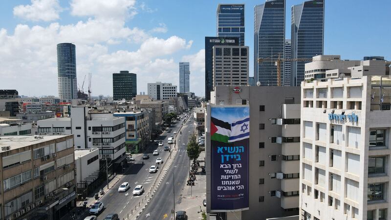 A billboard by Israeli anti-occupation group Peace Now adorns on a building in Tel Aviv. It reads: 'President Biden, welcome to the two countries we love the most.' AFP