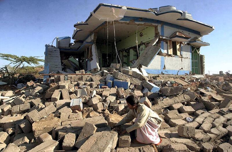 A woman looks for her belongings in the ruins of her house in Bound village in Bhuj district, 27 January 2001, following an 6.9 magnitude earthquake that struck northwestern India 26 January rendering thousands homeless. The death toll from the earthquake that has affected much of western Indian state of Gujarat was expected to rise above 10 000, with another 33 000 injured. (Photo by ARKO DATTA / AFP)