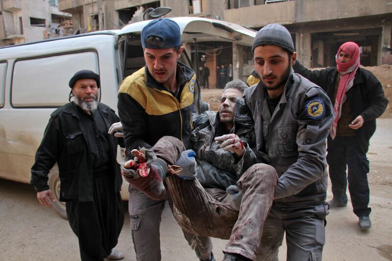 Civil Defence volunteers, known as the White Helmets, carry a wounded man into a makeshift hospital in the rebel-held town of Douma, following air strikes by regime forces on the besieged Eastern Ghouta region on the outskirts of the capital Damascus on February 20, 2018. Hamza Al-Ajweh / AFP