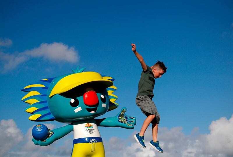 A young boy jumps off a statue of "Borobi", the official mascot of the 2018 Gold Coast Commonwealth Games near the Broadbeach Bowls Club venue in Australia. Adrian Dennis / AFP
