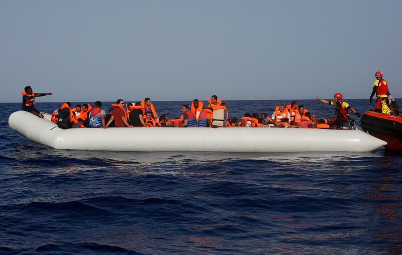FILE  - In this Saturday, June 30, 2018 file photo, an Open Arms lifeguard gives a thumbs-up to a migrant at the other end of a rubber boat in the middle of a rescue operation some 30 nautical miles off the coast of Libya in the Mediterranean Sea. The U.N. refugee agency says people smugglers are taking greater risks to ferry their human cargo toward Europe as Libyaâ€™s coast guard increasingly intercepts boats carrying migrants, increasing the likelihood that those on board may die on the Mediterranean journey. Thatâ€™s one of the key findings from the latest UNHCR report about efforts to reach Europe. (AP Photo/Renata Brito, File)