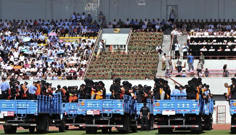 Trucks carrying criminals and suspects are seen during a mass sentencing rally at a stadium in Yili, Xinjiang with local authorities handing out judgements for 55 people and at least three death sentences for crimes such as "violent terrorism", state media said. Reuters