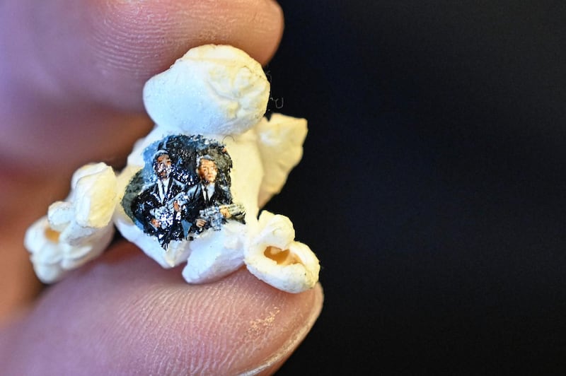 A picture taken on August 23, 2019 shows two armed men in black painted on a popcorn by Turkey's micro artist Hasan Kale in Istanbul.  His canvas could be anything from match sticks, seeds to razors and crown corks. Turkey's micro artist, also known as Turkish Microangelo in reference to Italian Renaissance sculptor and painter Michelangelo, has been hitting his brush onto tiny everyday objects for more than two decades. - RESTRICTED TO EDITORIAL USE - MANDATORY MENTION OF THE ARTIST UPON PUBLICATION - TO ILLUSTRATE THE EVENT AS SPECIFIED IN THE CAPTION
 / AFP / Ozan KOSE / RESTRICTED TO EDITORIAL USE - MANDATORY MENTION OF THE ARTIST UPON PUBLICATION - TO ILLUSTRATE THE EVENT AS SPECIFIED IN THE CAPTION
