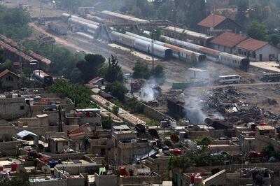 A picture taken on April 28, 2018 shows firefighters extinguishing a blaze at a train station near Yarmuk, a Palestinian refugee camp on the edge of Damascus, during regime shelling targeting Islamic State (IS) group positions in the  southern district of the capital. 
In 2015, IS overran most of Yarmuk, and the small numbers of other rebels and jihadists, including from Al-Qaeda's former affiliate, that had a presence there agreed to withdraw just a few weeks ago. / AFP PHOTO / Maher AL MOUNES