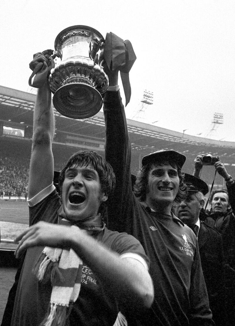 File photo dated 05-05-1974 - Liverpool captain Emlyn Hughes (left) and goalkeeper Ray Clemence show the FA Cup to the fans after Liverpool's 3-0 victory over Newcastle at Wembley. PA Photo