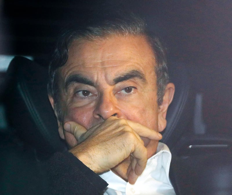 Former Nissan chairman Carlos Ghosn rides in a car from a building Wednesday, March 6, 2019, in Tokyo, after posting 1 billion yen ($8.9 million) in bail once an appeal by prosecutors against his release was rejected. Ghosn, the star auto executive credited with rescuing both Renault and Nissan, left a drab Tokyo detention center Wednesday after more than three months in custody, his identity obscured by a surgical mask, hat and construction worker's outfit.(Takuya Inaba/Kyodo News via AP)
