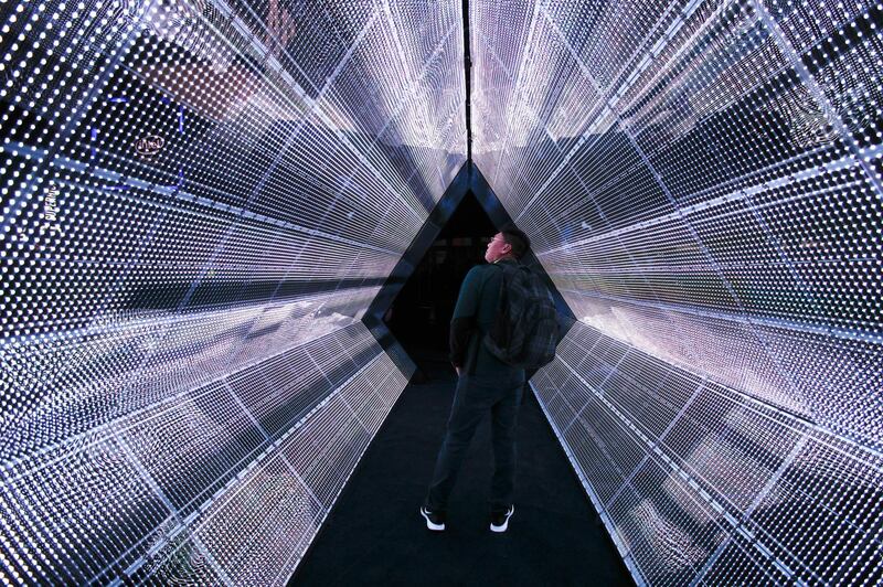 FILE - In this Tuesday, Jan. 9, 2018, file photo, a man stands in the 5G tunnel at the Intel booth at CES International in Las Vegas. Intel Corp. reports earnings, Thursday, Jan. 25, 2018. (AP Photo/Jae C. Hong, File)