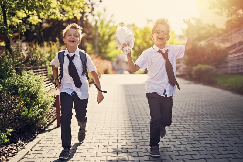 Two happy little boys walking in residential area walkway. Little brothers are going to school in the morning. Getty Images
