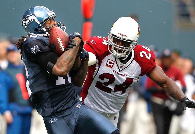 Seattle Seahawks' Sidney Rice, left, catches a pass under pressure from Arizona Cardinals' Adrian Wilson in the first half of a NFL football game, Sunday, Sept. 25, 2011, in Seattle. (AP Photo/Elaine Thompson) *** Local Caption ***  Cardinals Seahawks Football.JPEG-05589.jpg