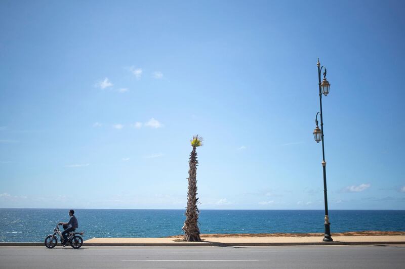 A man drives past the ocean amid home confinement orders in the Ocean neighbourhood in Rabat, Morocco. AP Photo