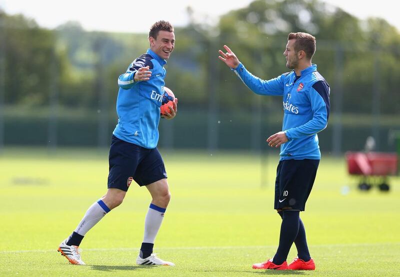 Laurent Koscielny and Jack Wilshere of Arsenal share a joke during Wednesday's training session for the FA Cup final. Clive Mason / Getty Images / May 14, 2014