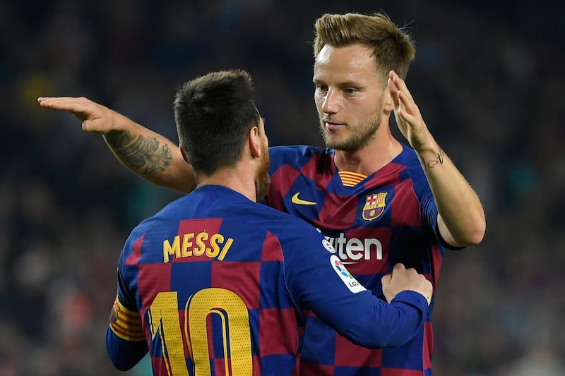 Barcelona's Croatian midfielder Ivan Rakitic (R) congratulates Barcelona's Argentine forward Lionel Messi for his second goal during the Spanish league football match between FC Barcelona and Real Valladolid FC at the Camp Nou stadium in Barcelona on October 29, 2019. / AFP / LLUIS GENE
