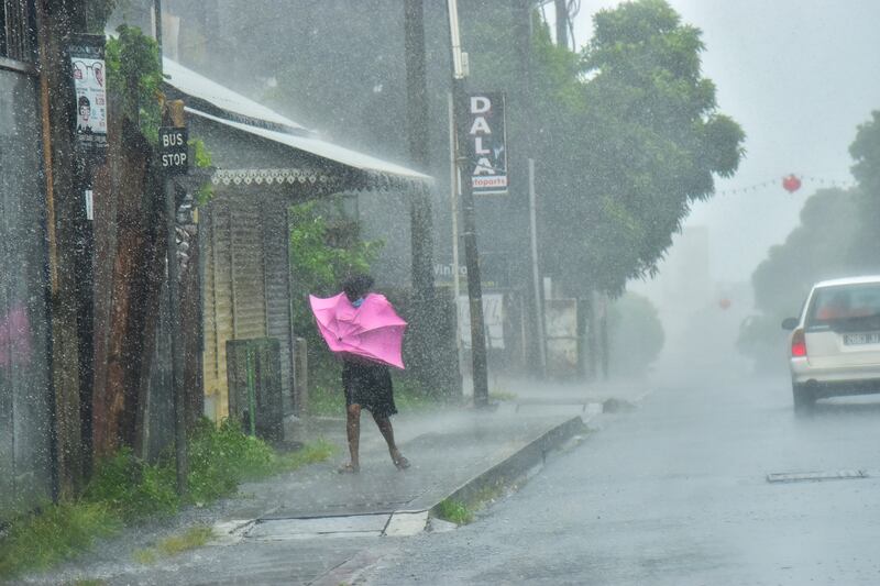 A woman fights winds in the Indian Ocean Island of Mauritius. AP