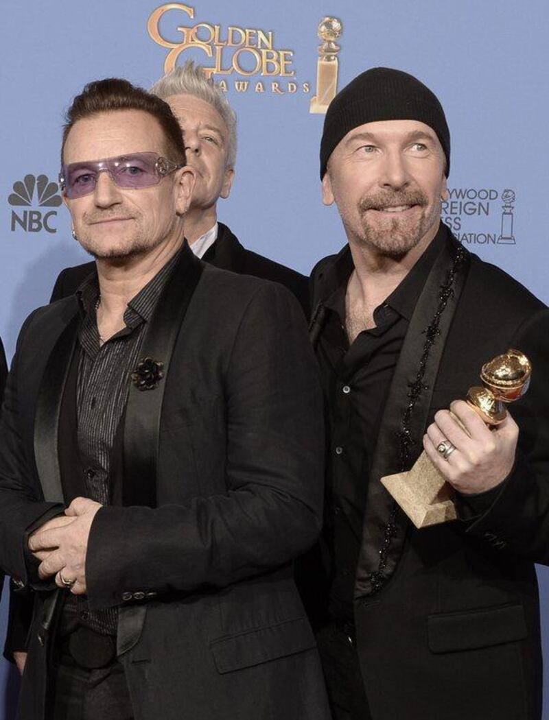 Musicians Bono and The Edge of U2, winners of Best Original Song for 'Ordinary Love' from 'Mandela: Long Walk to Freedom,' pose in the press room during the 71st Annual Golden Globe Awards held at The Beverly Hilton Hotel in Beverly Hills, California.   Kevin Winter/Getty Images/AFP