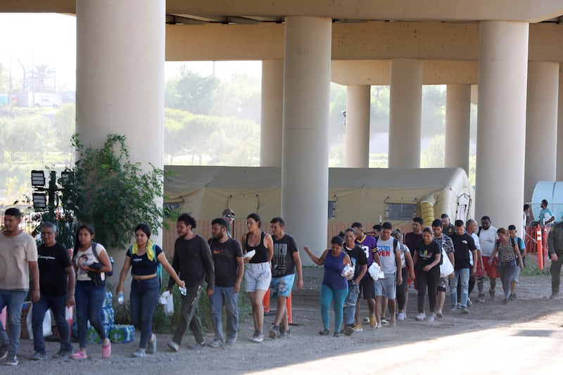 US Border Patrol agents process hundreds of migrants under the International Bridge II in Eagle Pass. AP 