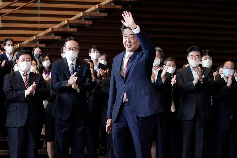 Japan's outgoing Prime Minister Shinzo Abe waves before leaving the prime minister's office. AP Photo