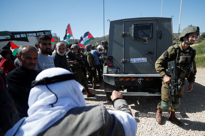 Israeli forces stand near their vehicle outside Ramallah as Palestinians protest against the repeal of a law banning settlement activity in some areas of the West Bank. Reuters